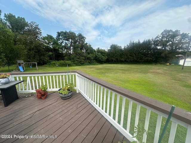 deck featuring a playground and a yard