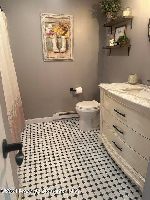 bathroom with vanity, toilet, and baseboard heating