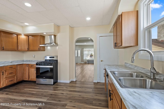 1324 Dartmouth St, Scranton, PA 18504 - kitchen with stainless steel appliances, wall chimney exhaust hood, arched walkways, dark wood-type flooring, and brown cabinets