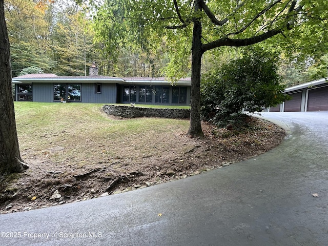 ranch-style home with a garage, a sunroom, and a front yard