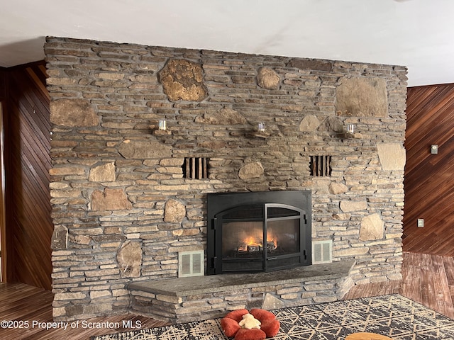 details featuring a stone fireplace and wood walls