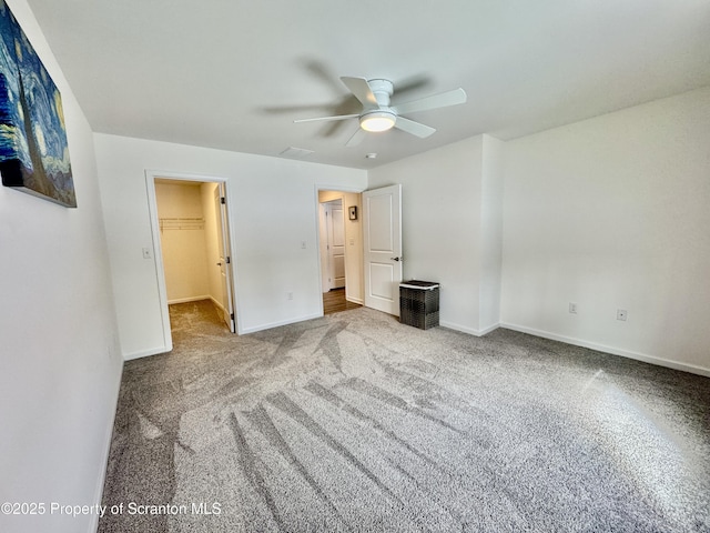 unfurnished bedroom with ceiling fan, carpet flooring, and a spacious closet