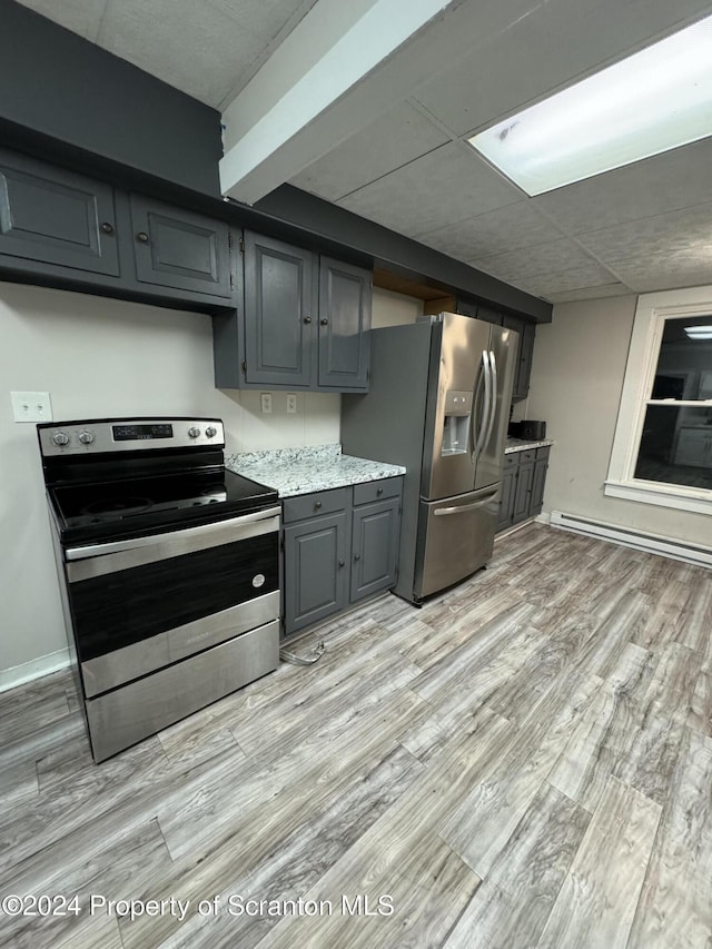 kitchen featuring appliances with stainless steel finishes, a paneled ceiling, gray cabinetry, baseboard heating, and light hardwood / wood-style floors