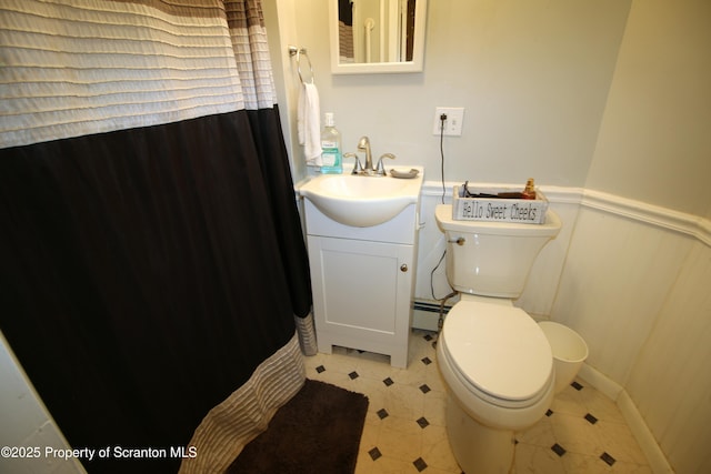 938 Oak St, Scranton, PA 18508 - bathroom with vanity, a baseboard radiator, a shower with curtain, a wainscoted wall, and tile patterned floors