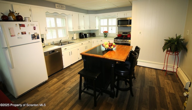938 Oak St, Scranton, PA 18508 - kitchen featuring appliances with stainless steel finishes, light countertops, dark wood-style flooring, white cabinetry, and a paneled ceiling