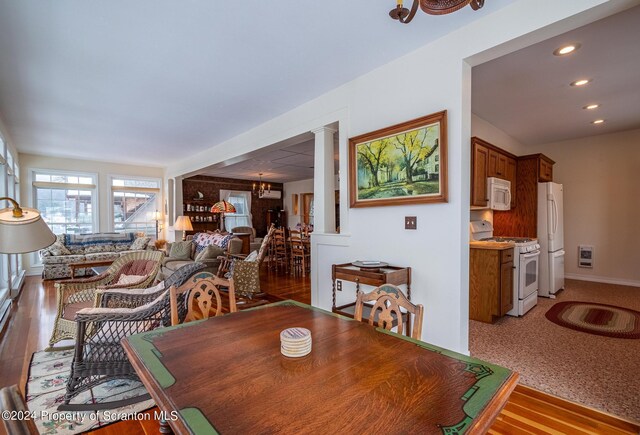 dining area featuring baseboards, ornate columns, an inviting chandelier, recessed lighting, and light wood-type flooring