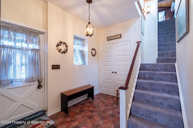 entryway featuring stairway, baseboards, and a wealth of natural light