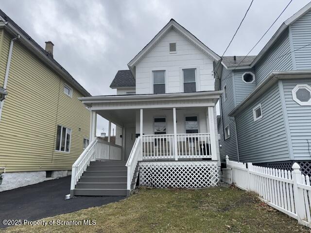 view of front of home featuring covered porch and fence