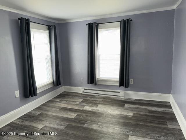 empty room with plenty of natural light, a baseboard heating unit, ornamental molding, and dark wood-type flooring