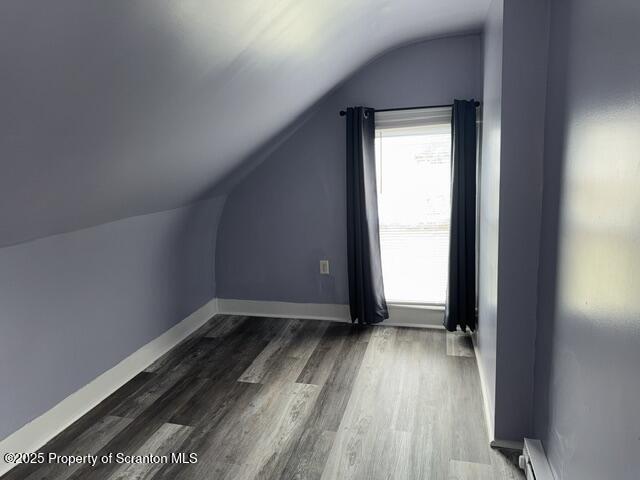 bonus room featuring baseboards, lofted ceiling, baseboard heating, and dark wood-style flooring