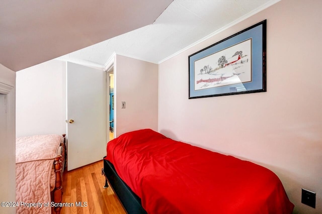 bedroom with light hardwood / wood-style flooring and ornamental molding