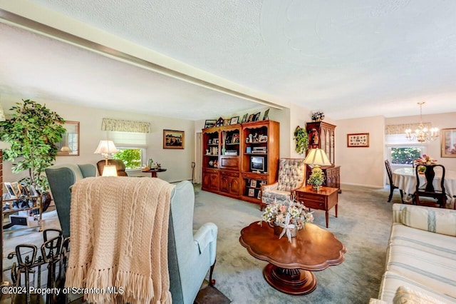 carpeted living room featuring a chandelier, a textured ceiling, and plenty of natural light