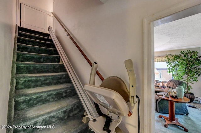 staircase featuring a textured ceiling