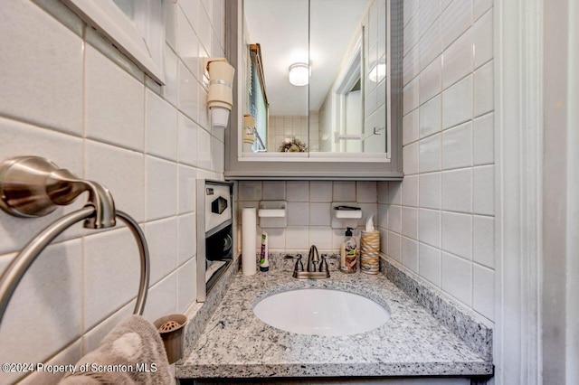 bathroom with decorative backsplash and vanity