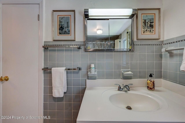 bathroom with vanity, tile walls, and walk in shower