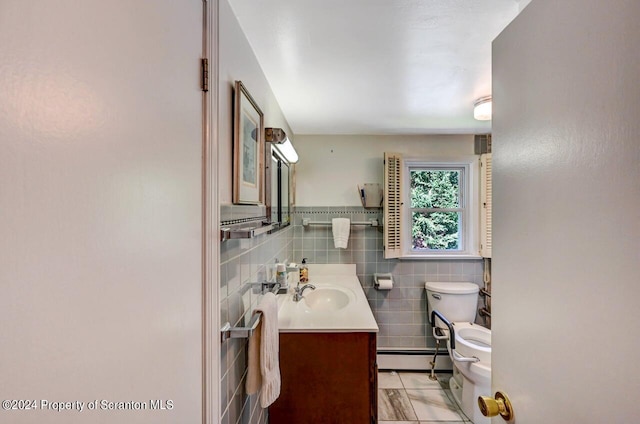 bathroom featuring vanity, toilet, tile walls, and a baseboard heating unit