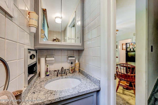 bathroom with tasteful backsplash and vanity