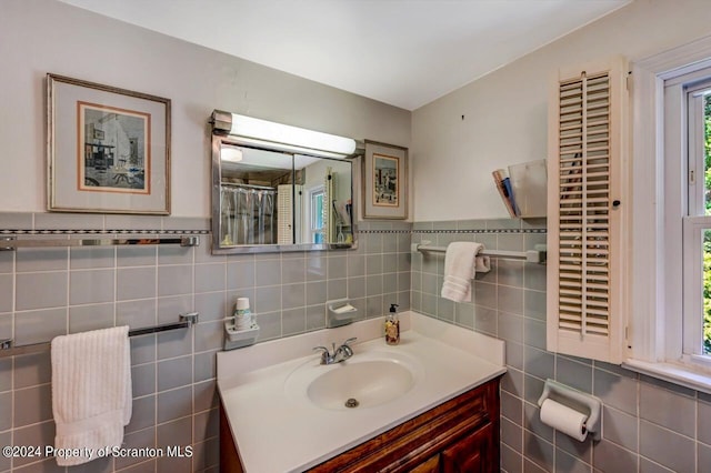 bathroom featuring vanity and tile walls