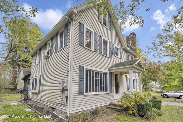 view of home's exterior featuring a chimney and cooling unit