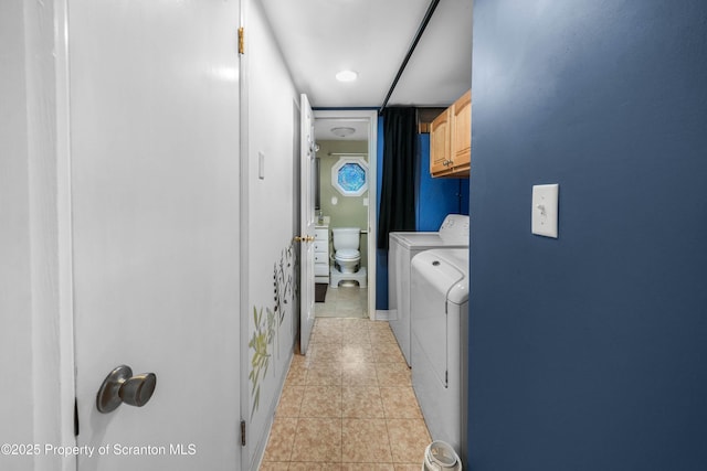 washroom with cabinet space, light tile patterned floors, and washing machine and clothes dryer