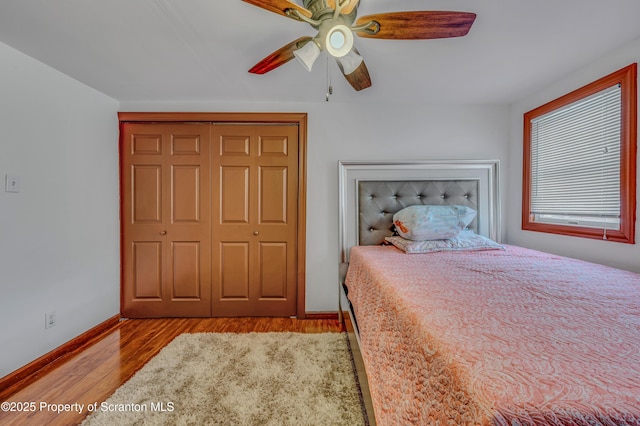 bedroom with light hardwood / wood-style flooring, ceiling fan, and a closet