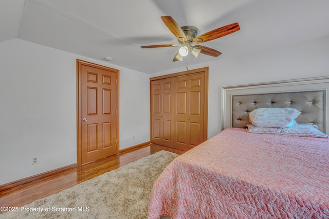 bedroom featuring lofted ceiling, light hardwood / wood-style flooring, a closet, and ceiling fan