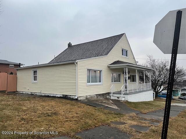 view of front of home with covered porch and a front lawn