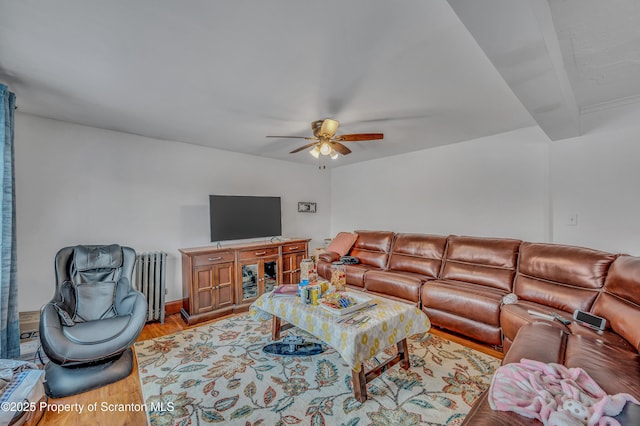 living room with beamed ceiling, ceiling fan, radiator, and light wood-type flooring