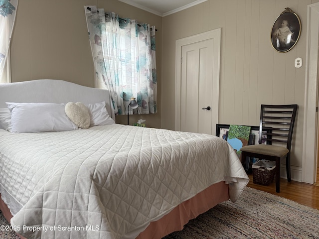 bedroom with crown molding and wood finished floors