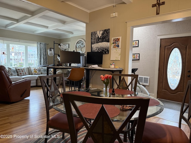 dining space featuring beamed ceiling, light wood-style flooring, coffered ceiling, and ornamental molding