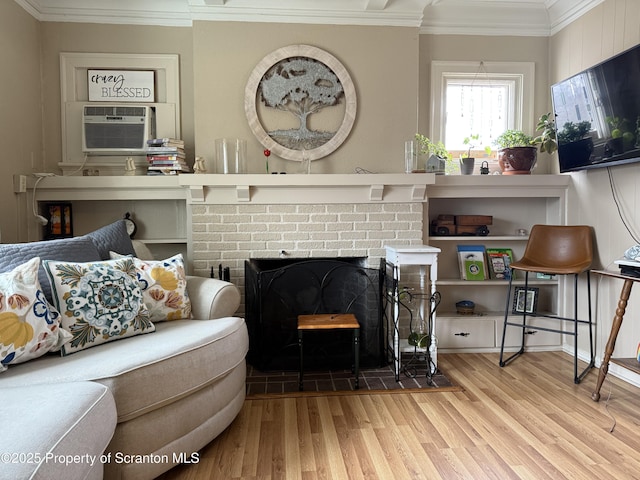 living room featuring cooling unit, a brick fireplace, wood finished floors, and ornamental molding