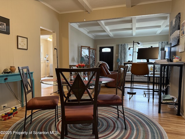 dining area with radiator, wood finished floors, coffered ceiling, ornamental molding, and beamed ceiling