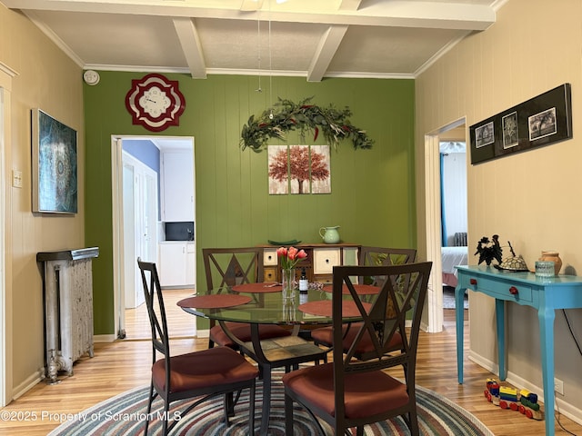 dining space featuring beamed ceiling, ceiling fan, light wood-type flooring, and baseboards