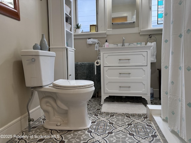 full bath featuring tile patterned floors, toilet, a shower with shower curtain, baseboards, and vanity