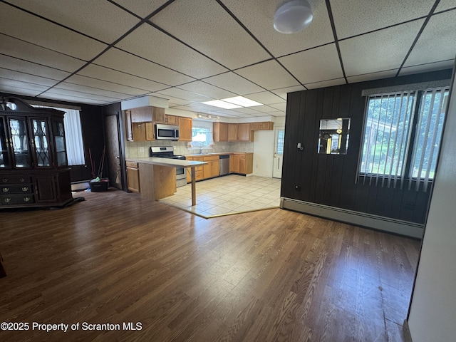 146 S Hyde Ave, Scranton, PA 18504 - kitchen featuring appliances with stainless steel finishes, a paneled ceiling, a baseboard heating unit, brown cabinets, and light countertops