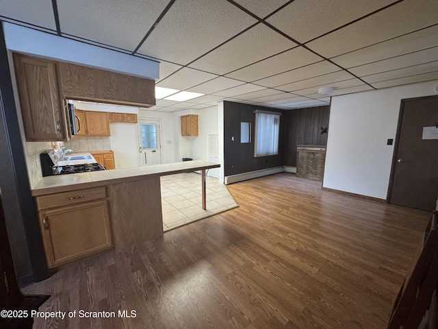 146 S Hyde Ave, Scranton, PA 18504 - kitchen with a paneled ceiling, dark wood-style floors, stainless steel microwave, a baseboard radiator, and tile counters