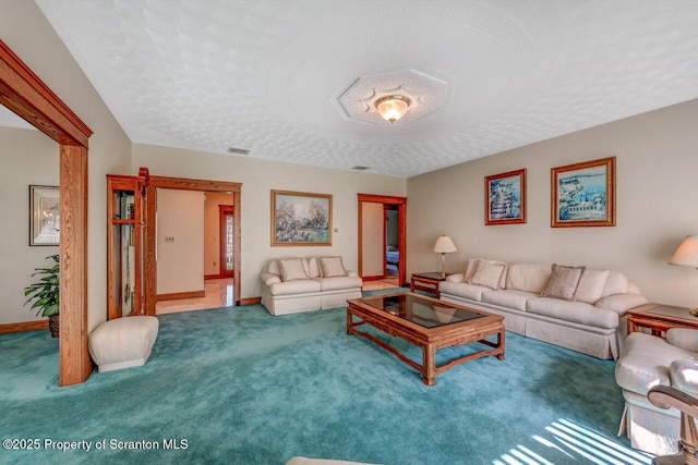 living room featuring carpet floors, baseboards, and visible vents