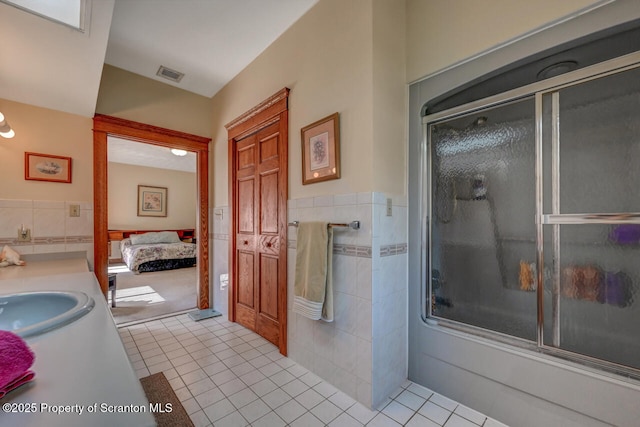 bathroom with visible vents, an enclosed shower, tile patterned floors, and tile walls
