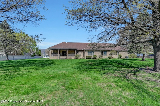 exterior space featuring covered porch, fence, and a front lawn