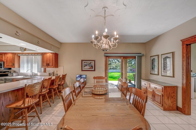dining room with a notable chandelier, light tile patterned flooring, and a wealth of natural light