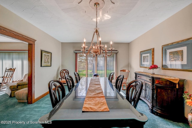 dining space featuring baseboards, a chandelier, and carpet
