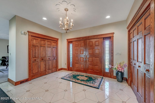 foyer featuring recessed lighting, baseboards, and an inviting chandelier
