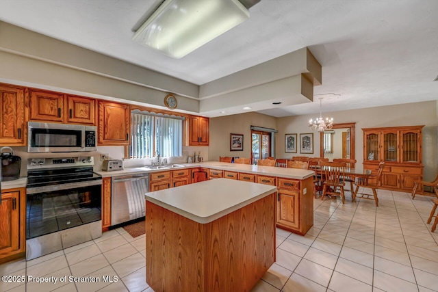 kitchen with light countertops, appliances with stainless steel finishes, light tile patterned floors, and a peninsula