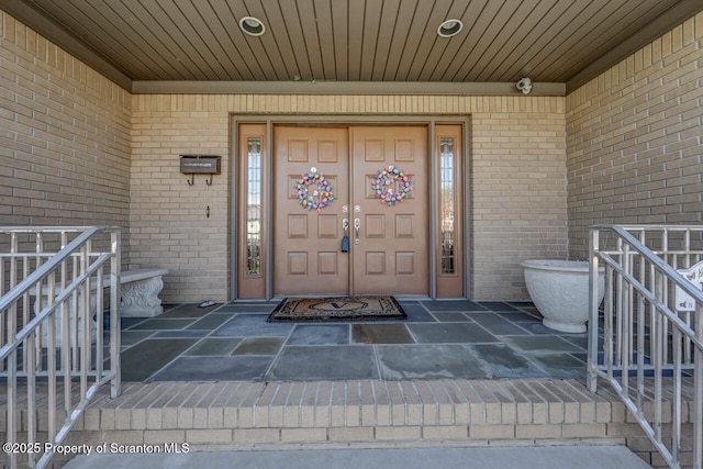 property entrance featuring brick siding and a porch