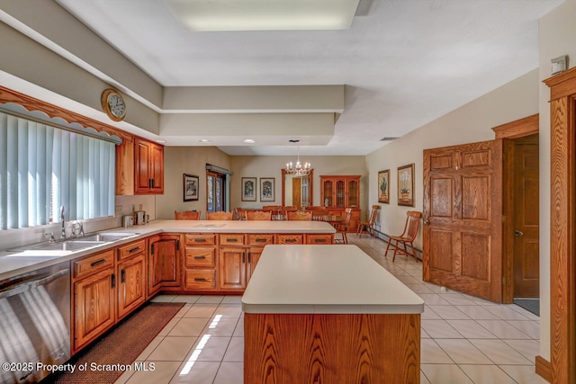 kitchen featuring stainless steel dishwasher, a sink, light tile patterned floors, light countertops, and a peninsula