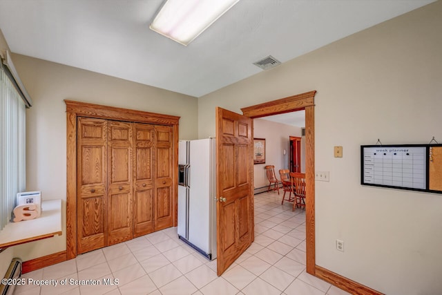 hallway with baseboards, visible vents, light tile patterned floors, and a baseboard radiator