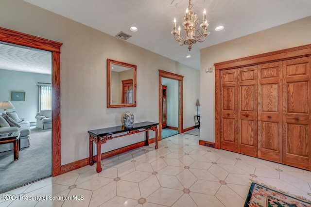 foyer entrance with visible vents, recessed lighting, baseboards, and an inviting chandelier