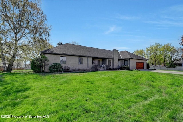 ranch-style house with a front lawn, brick siding, a garage, a chimney, and concrete driveway