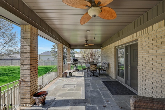 view of patio with fence, outdoor dining area, and ceiling fan