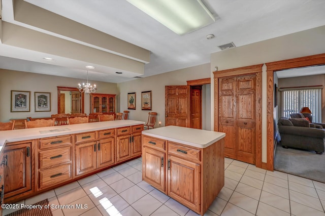 kitchen with visible vents, open floor plan, light countertops, light tile patterned floors, and a notable chandelier